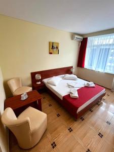 海王星市的住宿－Hotel Callatis，卧室配有1张床、1张桌子和1把椅子