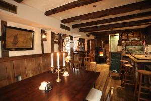 THE CORNISH ARMS Guest House في سولينغين: غرفة طعام مع طاولة خشبية مع الشموع عليها