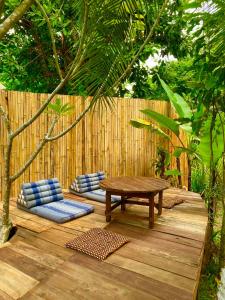 - une terrasse en bois avec une table et deux oreillers bleus dans l'établissement Buzzas @ Pai Chan, à Pai
