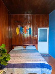 ein Schlafzimmer mit einem Bett mit einer Holzwand in der Unterkunft Dorry Le's House in Gia Nghĩa