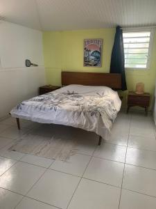 een slaapkamer met een bed in een kamer bij Le Madras du Tombolo in Sainte-Marie