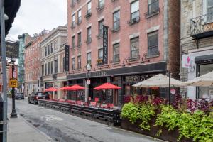 un restaurante con sombrillas rojas en una calle de la ciudad en Charming N End 2BR on Salem St BOS-451, en Boston