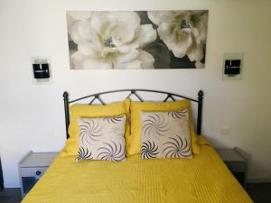 - un lit avec deux oreillers et un tableau mural dans l'établissement Maison de vacances St Cyprien Plage, à Saint-Cyprien