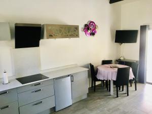 une cuisine avec une table et une salle à manger dans l'établissement Maison de vacances St Cyprien Plage, à Saint-Cyprien