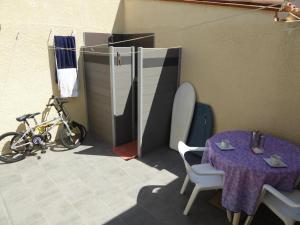 une chambre avec une table et un vélo à côté d'un bâtiment dans l'établissement Maison de vacances St Cyprien Plage, à Saint-Cyprien