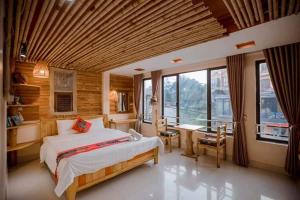 a bedroom with a bed and a desk and windows at Sapa indigo inn in Sapa