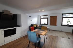 a living room with a couch a table and a tv at Louisappart - Eupen Zentrum in Eupen