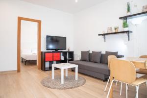 Renovado apartamento a 10 min del Aeropuerto y a 3 min de IFEMA في مدريد: غرفة معيشة مع أريكة وطاولة