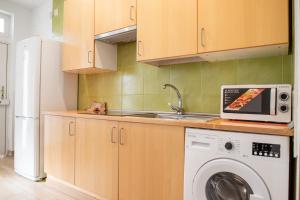 a kitchen with a sink and a washing machine at Renovado apartamento a 10 min del Aeropuerto y a 3 min de IFEMA in Madrid