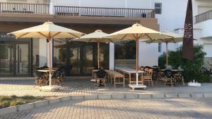 a patio with tables and chairs and umbrellas at Almaza Bay, 2 bd ground floor (Prime location) in Marsa Matruh