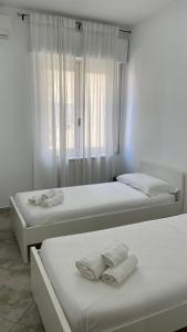 two beds in a room with white walls and a window at LT Apartment Tropea in Tropea