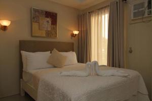 Un dormitorio con una cama con dos cisnes. en Aberrise Country Villa Pension Hotel, en Dumaguete