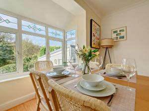 a dining room with a table with chairs and glasses at 4 Bed in Aberporth 93783 in Aberporth