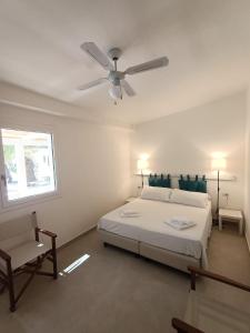 1 dormitorio con 1 cama y ventilador de techo en Lido Di Alghero Rooms on the Beach, en Alghero