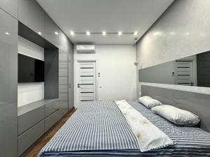 ein kleines Schlafzimmer mit einem Bett und einem TV in der Unterkunft Arcadia Luxury Apartments in Odessa