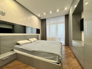 a bedroom with a bed and a large window at Arcadia Luxury Apartments in Odesa