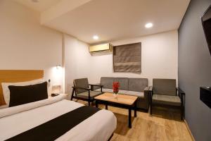 a hotel room with a bed and a couch at Super Townhouse City Centre 2 Downtown - Managed by Company in Kolkata