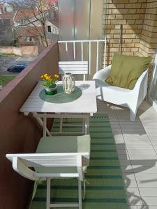 Biały stół i krzesła na balkonie w obiekcie Apartman Terra centar, free parking w mieście Osijek