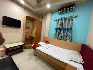 um quarto de hospital com uma cama e uma televisão em Starline Hotel em Agartala