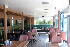 ディディムにあるMavi Restaurant & Bistroのピンクの椅子とテーブル、窓のあるレストラン