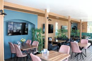een restaurant met houten tafels en roze stoelen bij Mavi Restaurant & Bistro in Didim