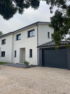 a white house with a garage at Grande villa avec piscine et spa in Longages