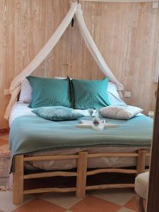 uma cama com almofadas azuis e uma mesa em «Gîte H2O SPA» à Précy-sur-Oise. em Précy-sur-Oise