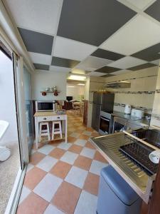 uma grande cozinha com piso em xadrez em «Gîte H2O SPA» à Précy-sur-Oise. em Précy-sur-Oise