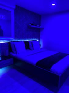 a blue bedroom with a large bed with blue lighting at Atelier chaleureux 40m2 - proche CDG Parc des expo in Tremblay-En-France