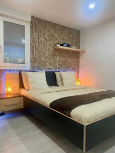 a bedroom with a large bed with lights on it at Atelier chaleureux - CDG in Tremblay En France