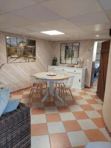 uma cozinha com mesa e cadeiras num quarto em «Gîte H2O SPA» à Précy-sur-Oise. em Précy-sur-Oise