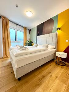 ein großes Schlafzimmer mit einem großen Bett mit einem großen weißen Kopfteil in der Unterkunft Kreative Wohnung mit Balkon in Wien