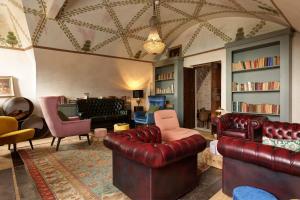 a living room with red leather furniture and bookshelves at Villa Balis Crema Verona Hills in Grezzana