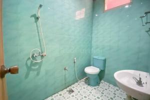 a bathroom with a toilet and a sink at Wisma Sodikin Mitra RedDoorz in Palembang