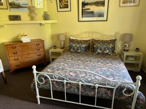 1 dormitorio con cama y tocador de madera en River Front Estate, en Huonville