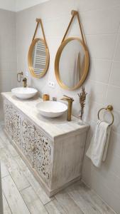 a bathroom with two sinks and two mirrors at Lou Masadous : Magnifique villa tout confort avec piscine chauffée 11x3.5 in Montauroux +4 photos