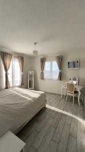 a bedroom with a large bed and a table and chairs at Lou Masadous : Magnifique villa tout confort avec piscine chauffée 11x3.5 in Montauroux