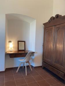 een bureau met een stoel naast een houten kast bij Casa Margarina - Self catering apartment in Saluzzo
