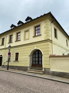 a large yellow building on the side of a street at Kutna Hora perfect apartment in Kutná Hora
