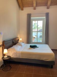 1 dormitorio con 1 cama grande y ventana en Casa Margarina - Self catering apartment en Saluzzo