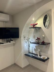 a room with a aquarium and a clock on a wall at Casa vacanze da Mely in Marsala +16 photos