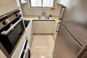 a small kitchen with a sink and a refrigerator at Prime 1 BHK in Hiranandani Powai in Mumbai