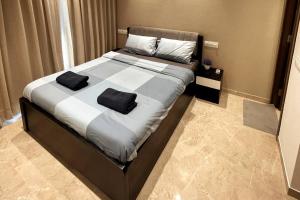 a bedroom with a large bed with two pillows on it at Prime 1 BHK in Hiranandani Powai in Mumbai