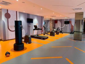 a gym with treadmills and exercise equipment on the floor at Prime 1 BHK in Hiranandani Powai in Mumbai