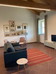sala de estar con sofá azul y alfombra en Casa Margarina - Self catering apartment en Saluzzo