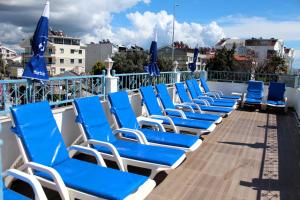 eine Reihe blauer Liegestühle auf einem Kreuzfahrtschiff in der Unterkunft Mavi Restaurant & Bistro in Didim