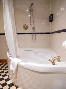a white tub in a bathroom with a shower at The Vestry in Chichester