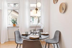 a dining room with a black table and chairs at Helle zentrumsnahe familienfreundliche Ferienwohnung in Fellbach