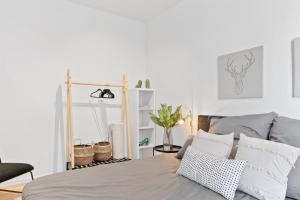 een witte slaapkamer met een bed en een stoel bij Helle zentrumsnahe familienfreundliche Ferienwohnung in Fellbach