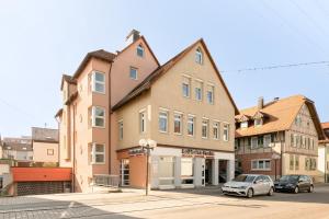 a building with two cars parked in front of it at Helle zentrumsnahe familienfreundliche Ferienwohnung in Fellbach